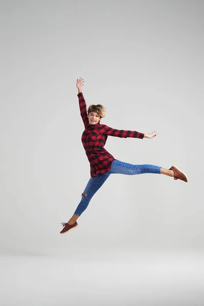 Jovem garota enérgica pulando no estúdio — Fotografia de Stock