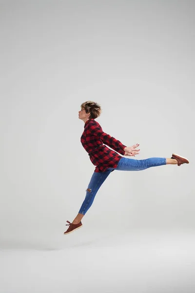 Joven chica deportiva haciendo splits en el aire en el estudio —  Fotos de Stock