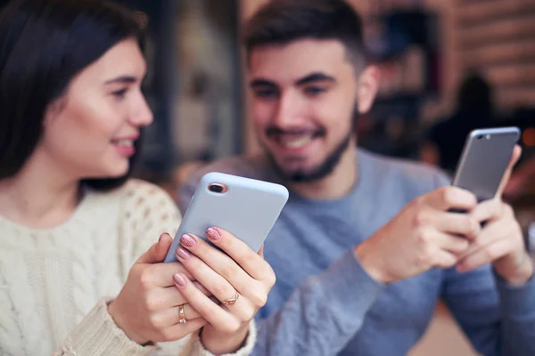 Vackert par med telefoner på café — Stockfoto