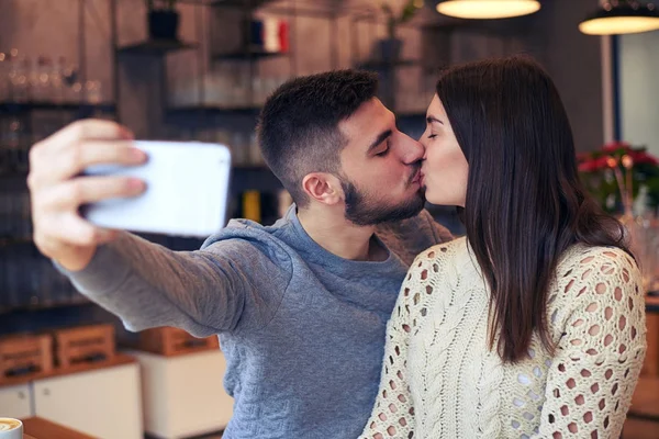 Couple faisant selfie tout en embrassant au café — Photo