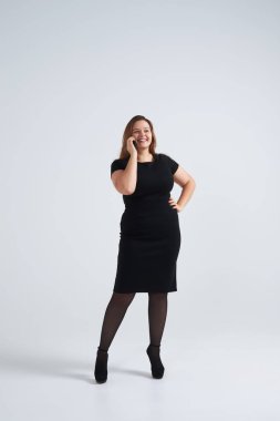 Mutlu genç iş kadını telefonda konuşurken akıllı ofis kıyafet