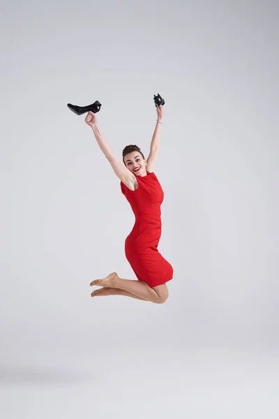 Бізнес-леді стрибає радісно з взуттям в руках — стокове фото