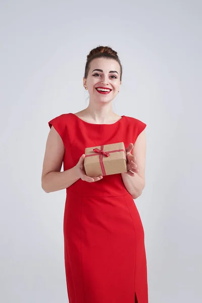 Mosolyogva gazdaság a jelen box, kezében piros ruhás nő — Stock Fotó