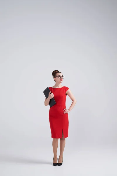 Kobieta w okularach posiadających folder i patrząc w prawo — Zdjęcie stockowe