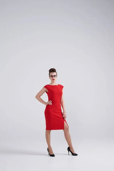 Preciosa mujer en vestido rojo y gafas posando en la cámara — Foto de Stock