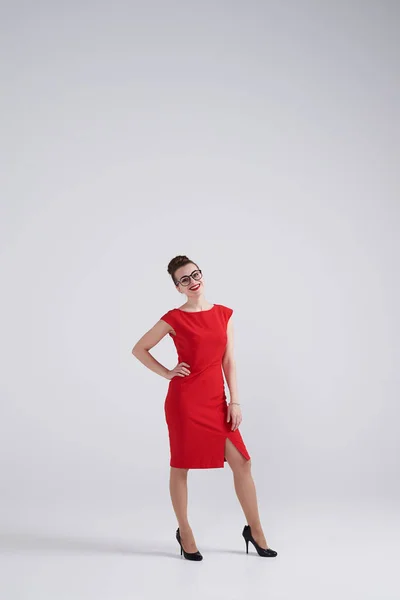 Sexy woman in red dress and glassed posing at studio — Stock Photo, Image