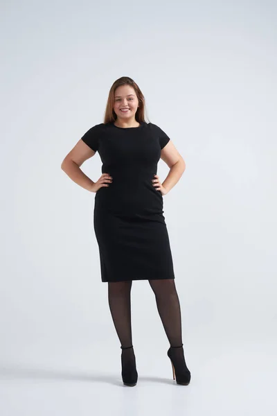 Woman in classic black dress standing against background — Stock Photo, Image