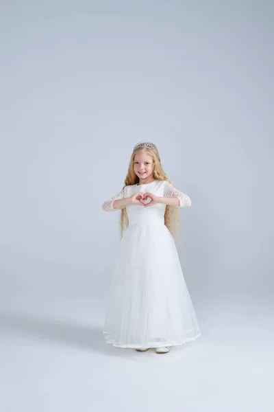 Chica en vestido blanco y diadema haciendo forma de corazón — Foto de Stock