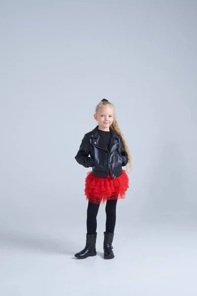 Menina pequena em jaqueta de couro de mãos dadas em bolsos — Fotografia de Stock