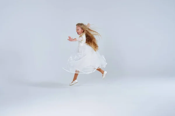 Vrolijke blonde meisje in jurk plezier op studio — Stockfoto