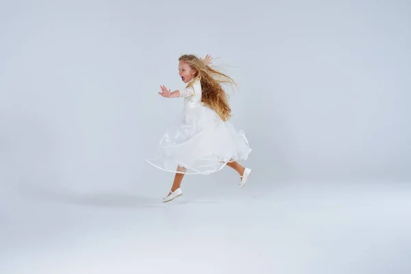 Menina loira alegre no vestido se divertindo no estúdio — Fotografia de Stock