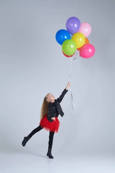 Menina feliz em estilo rock roupas segurando balões — Fotografia de Stock