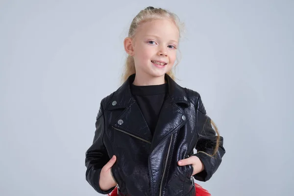 Smiling blonde girl wearing leather jacket posing at camera — Stock Photo, Image