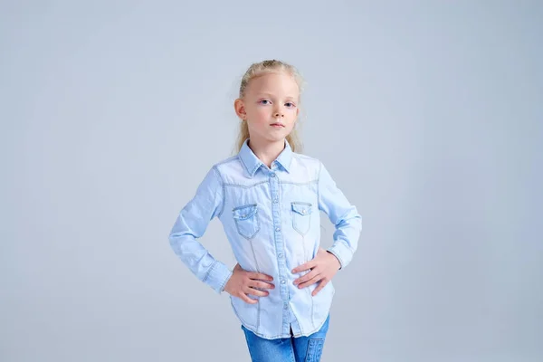 Small blonde girl with hands on hips looking at camera — Stock Photo, Image