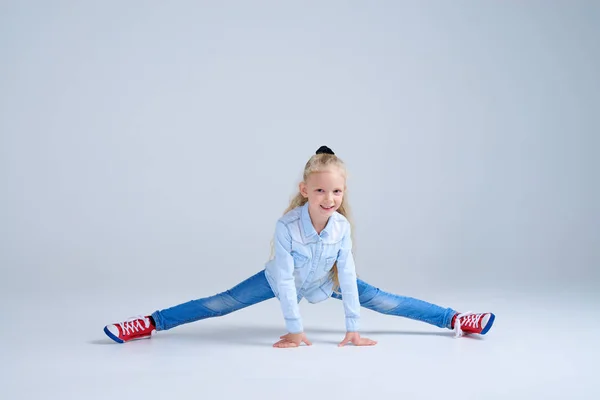 Flexible little girl doing the splits at studio — Stock Photo, Image