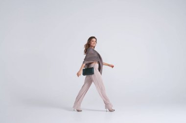 Model arka plan karşı yürüyüş giyen trend giyim