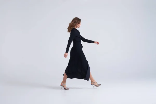 Mujer vistiendo vestido largo negro caminando —  Fotos de Stock