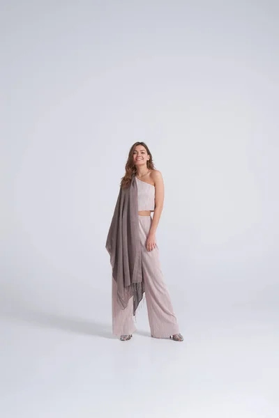 Модна жінка в модному одязі і шарфі позує в студії — стокове фото