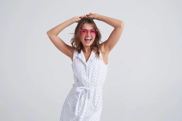 Mujer bonita en gafas de sol rosadas divirtiéndose mientras posa — Foto de Stock