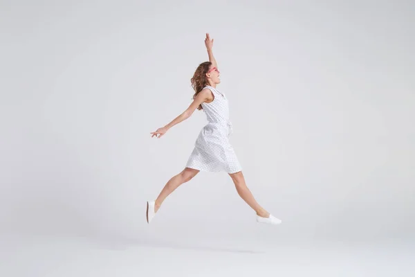 Mooi meisje met jurk jumping geïsoleerd op achtergrond — Stockfoto
