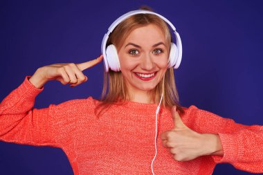 mutlu sarışın kulaklıktan işaret ve başparmak gösterilmesini