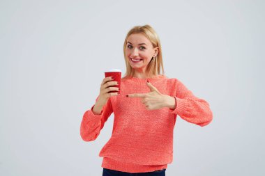 Kağıt kahve Kupası işaret eden genç sarışın