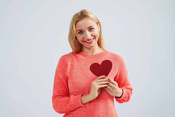 Sonriente rubia sosteniendo pequeño corazón rojo —  Fotos de Stock