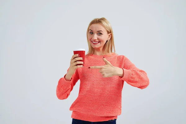 Young blond pointing on paper coffee cup — Stock Photo, Image