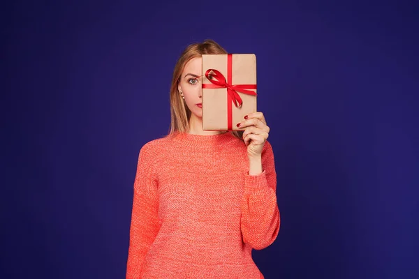 Blondine versteckt Gesicht hinter Geschenkbox — Stockfoto