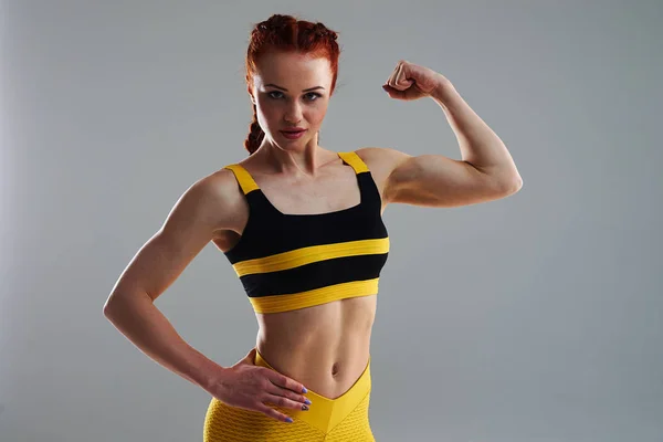 Jonge vrouw poseren en tonen van de biceps — Stockfoto