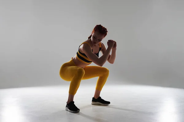 Kvinna i sportkläder gör knäböj — Stockfoto