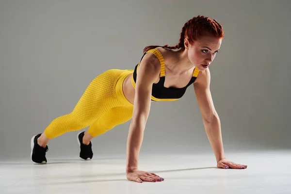 Спортсменка делает упражнения на доске — стоковое фото
