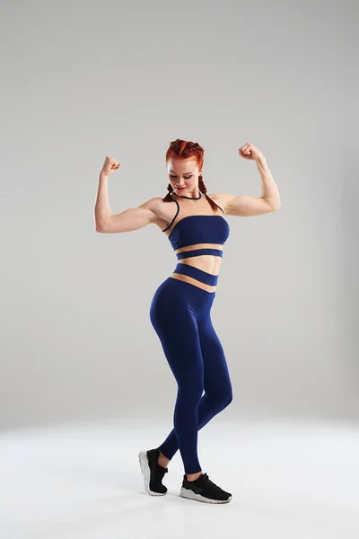 Fit woman in blue sportswear posing in studio — Stock Photo, Image