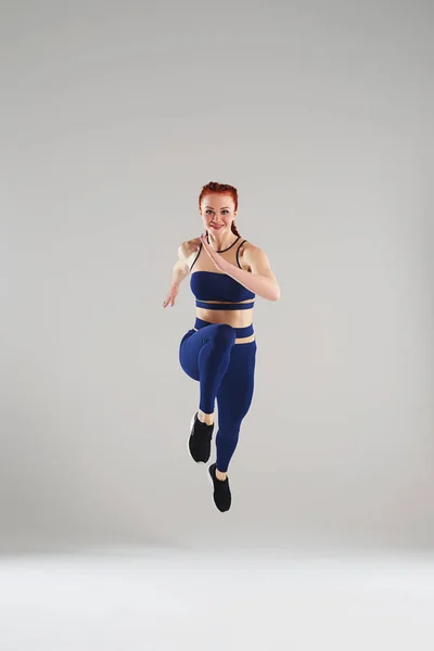 Підходить жінка в блакитному спортивному одязі біжить — стокове фото