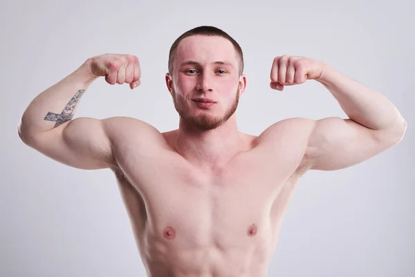 Närbild ogf ung stark man visar hans biceps — Stockfoto