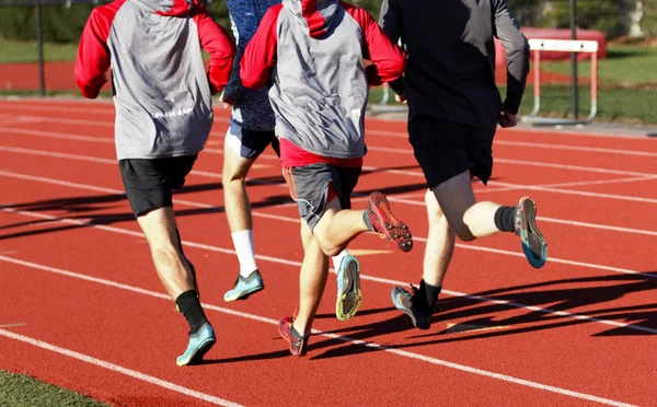 Grupo de meninos correndo em uma pista por trás — Fotografia de Stock