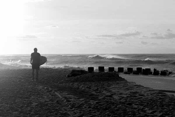 Surfer promenader ner till stranden vid soluppgången — Stockfoto