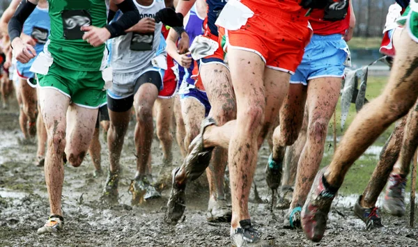 Middelbare school jongens langlauf racen in de modder — Stockfoto