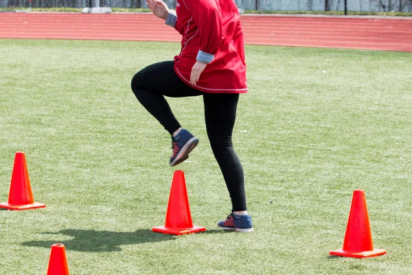 Sportler macht Laufübungen über Kegel — Stockfoto