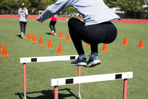 Atleta fêmea se limita sobre um obstáculo — Fotografia de Stock