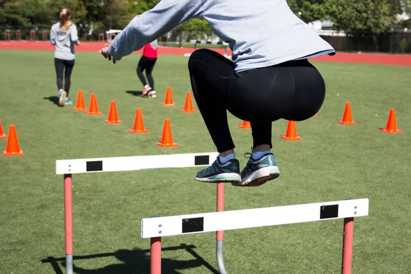 Atleta femenina bordea un obstáculo — Foto de Stock