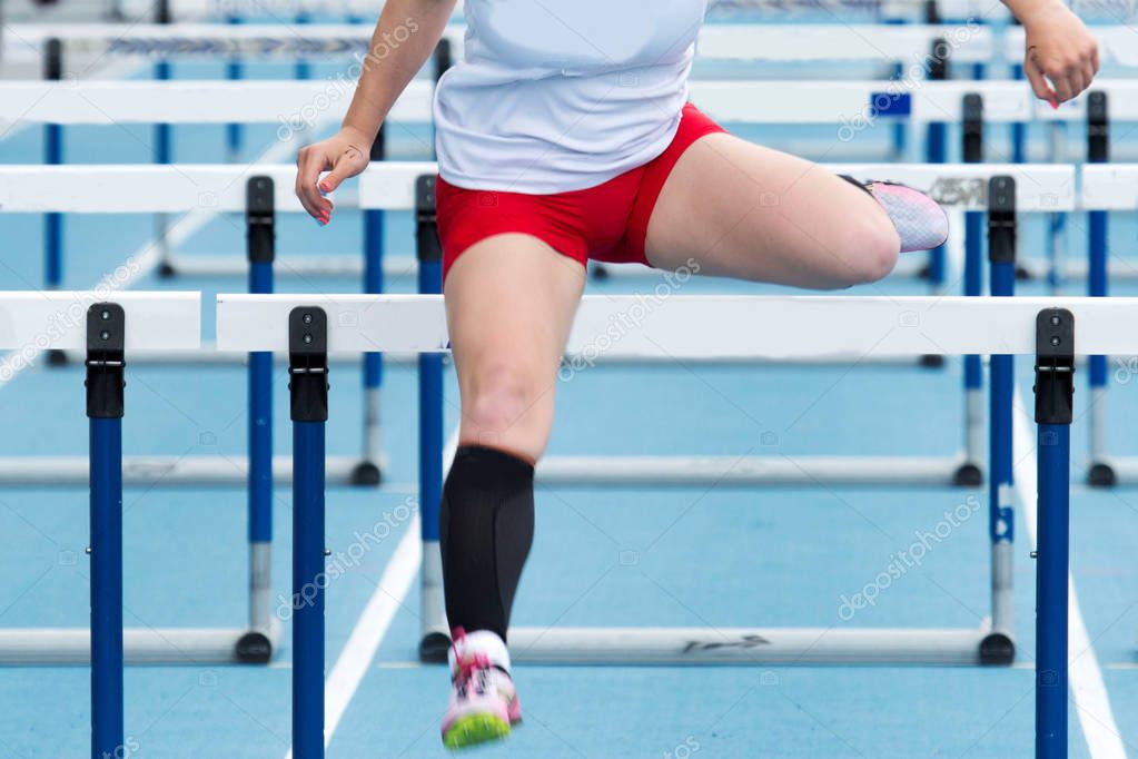 High school girl racing in the hurdles