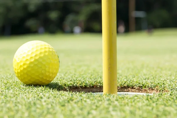 穴の縁に黄色のゴルフ ・ ボール — ストック写真