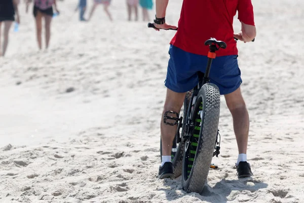 Um homem em uma bicicleta roda gorda na praia — Fotografia de Stock