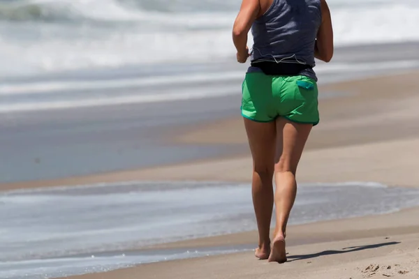 Женщины бегут по береговой линии на пляже — стоковое фото