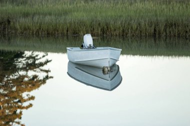 Küçük tekne palamarla ve erken akşam göle yansıtan 