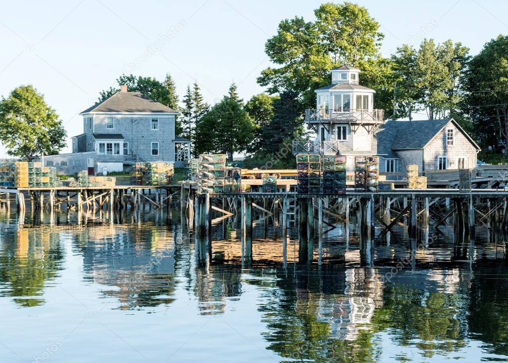 Houses with docks stacked with lobster traps reflecting in the w
