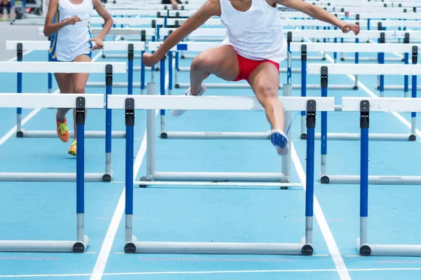 Två gymnasiet flickor racing i 100 meter häck — Stockfoto