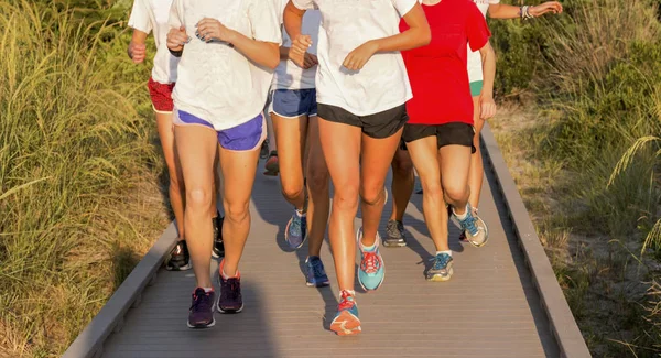 Meninas do ensino médio correndo em um calçadão — Fotografia de Stock