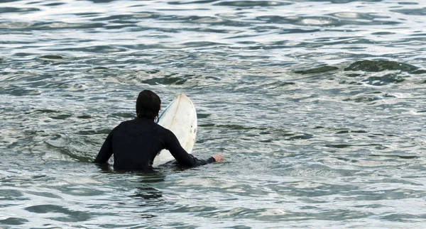 Surfista em suíte preta esperando por uma onda — Fotografia de Stock